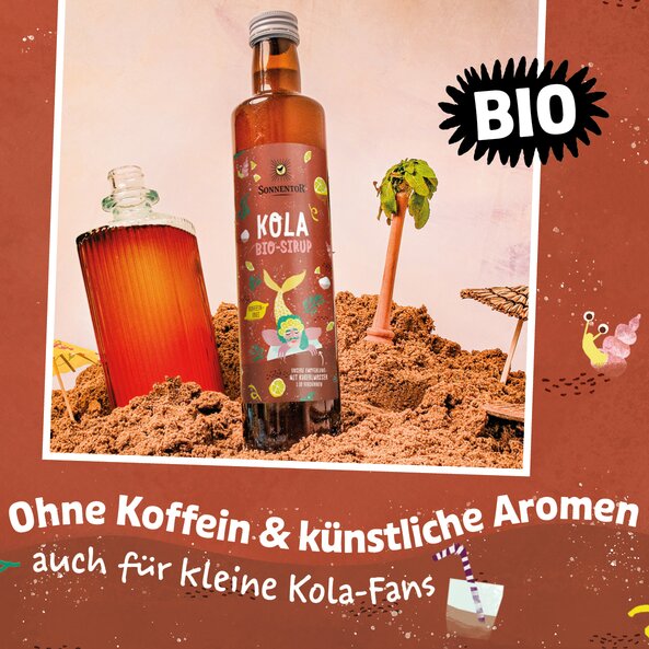 Kola Sirup Flasche in Strandszene mit Getränk, Palme und Text „BIO“ sowie „Ohne Koffein & künstliche Aromen auch für kleine Kola-Fans“